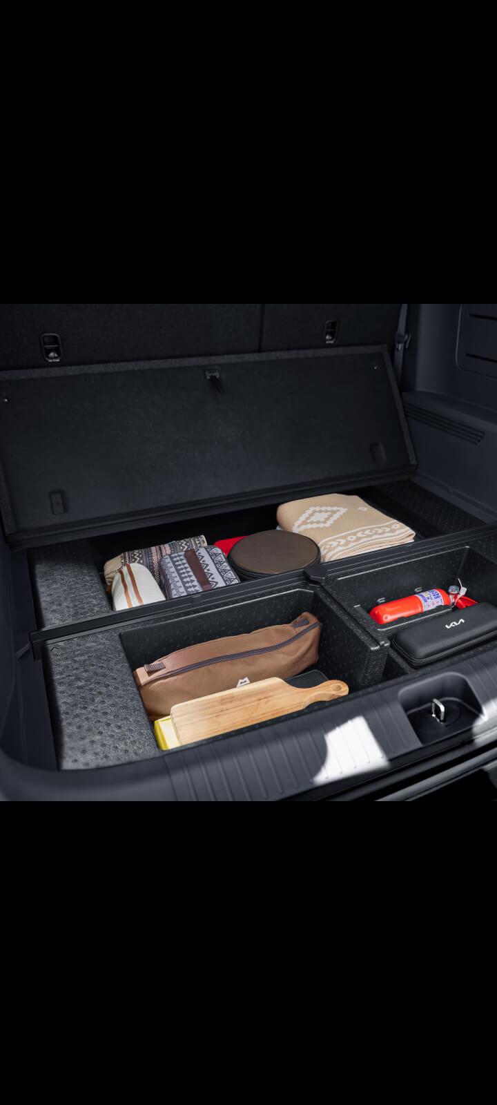 Innenaufnahme des Kofferraums im Kia PV5 Passenger mit integriertem Staufächern.